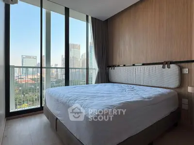 Modern bedroom with floor-to-ceiling windows offering stunning city view