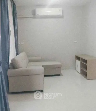 Cozy living room with modern sofa and air conditioning, perfect for relaxation.