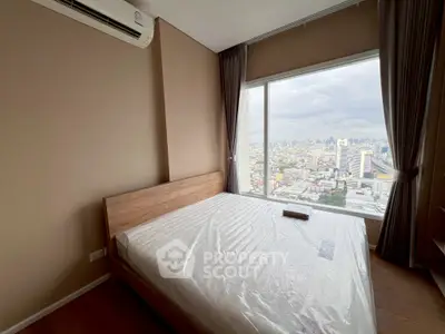 Modern bedroom with city view and large window, featuring a minimalist design and air conditioning.