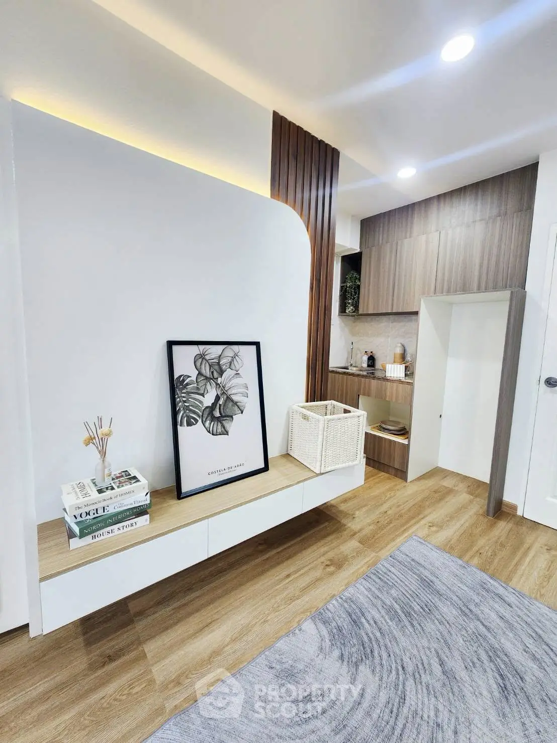 Modern living room with stylish decor and wooden flooring, featuring a cozy seating area and elegant wall art.