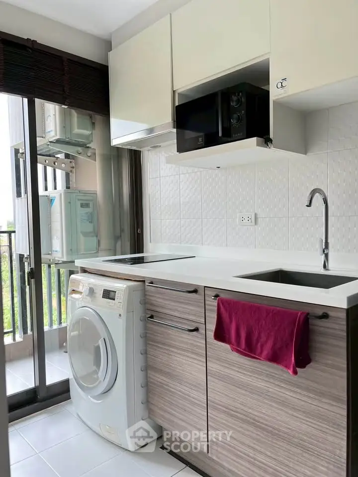 Modern kitchen with washing machine and sleek cabinetry in a bright apartment