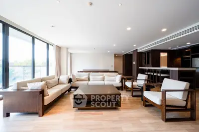 Spacious modern living room with elegant wooden furniture and large windows for natural light.