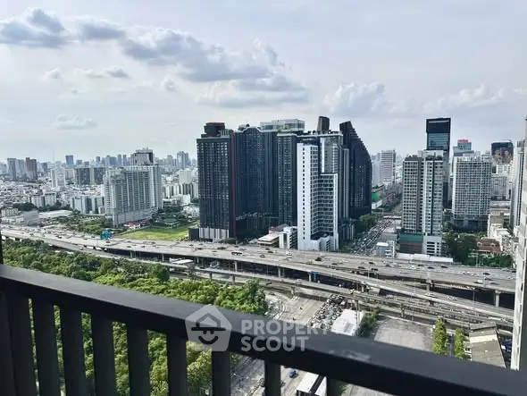 Stunning cityscape view from high-rise balcony overlooking urban skyline and highways.