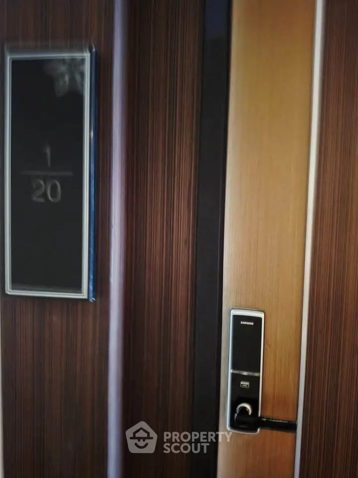Modern apartment door with electronic lock and stylish wood paneling.