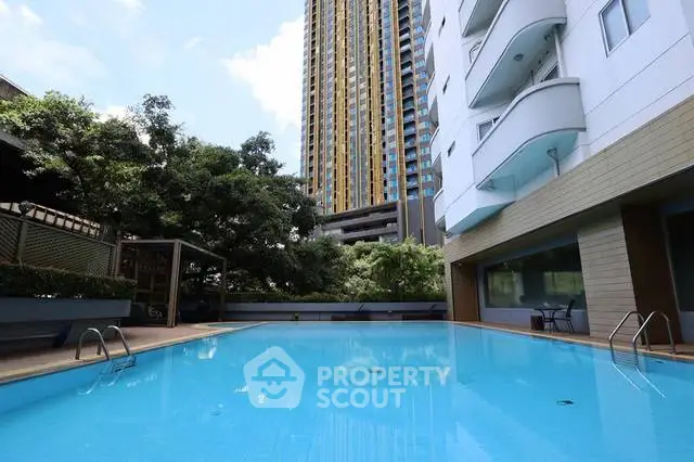 Luxurious residential building with a stunning outdoor pool and modern architecture.