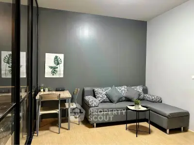 Modern living room with stylish gray sofa and dining area, perfect for cozy urban living.