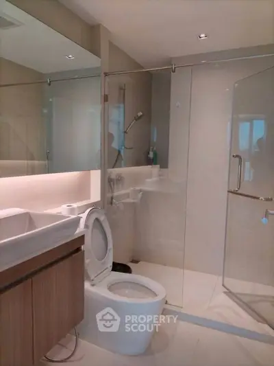 Modern bathroom with glass shower and sleek fixtures in a contemporary home.