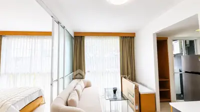Bright and modern living space with cozy sofa and large windows in a stylish apartment.