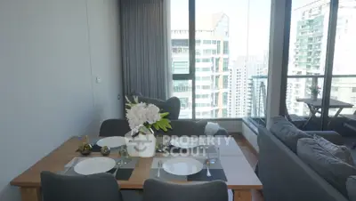 Modern dining area with city view, featuring elegant table setting and cozy seating in a high-rise apartment.