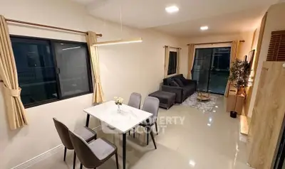 Modern living room with elegant dining area and cozy seating, featuring large windows and stylish decor.