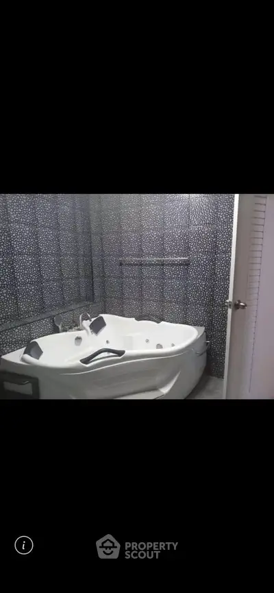 Luxurious bathroom with modern jacuzzi tub and stylish tile design.