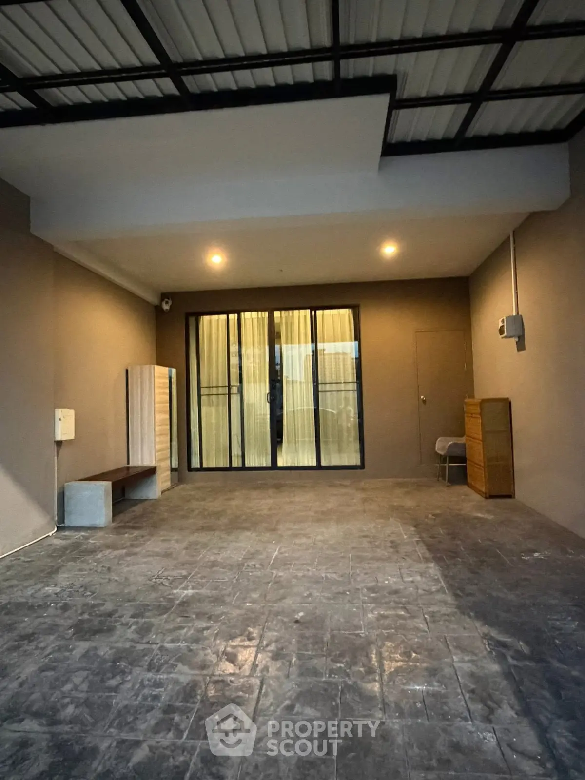 Spacious covered parking area with modern lighting and sliding glass doors.