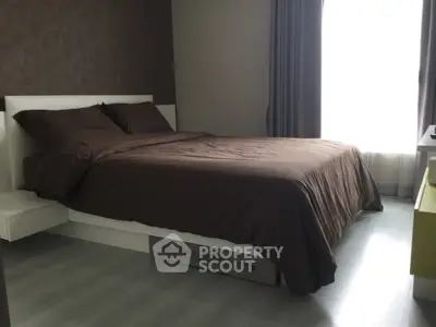 Modern bedroom with sleek design and natural light, featuring a comfortable bed and stylish decor.