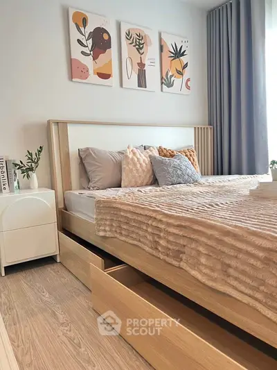 Modern bedroom with stylish decor and under-bed storage in a cozy apartment.