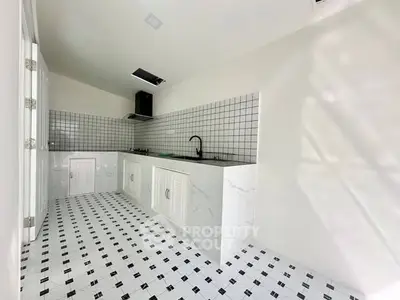 Modern kitchen with sleek white cabinets and stylish black and white tile flooring