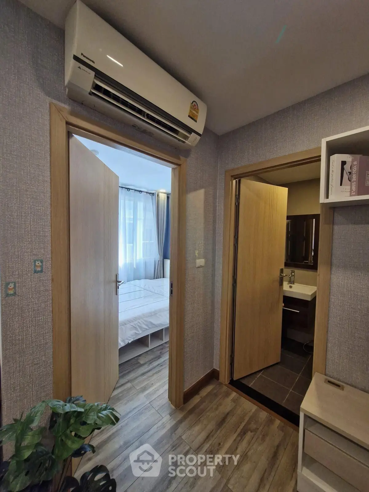 Modern apartment interior with air conditioning, bedroom, and bathroom view.