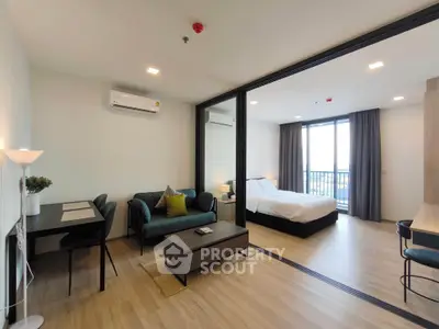 Modern open-plan living room and bedroom with stylish decor and natural light.