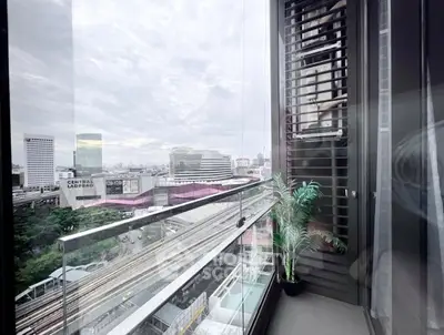 Stunning city view from modern balcony with glass railing and potted plant, perfect for urban living.