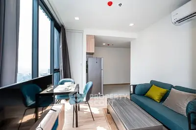Modern living room with dining area and large windows in a high-rise apartment.