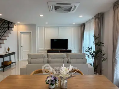 Elegant living room with modern decor, cozy sofa, and stylish TV setup, perfect for relaxation and entertainment.