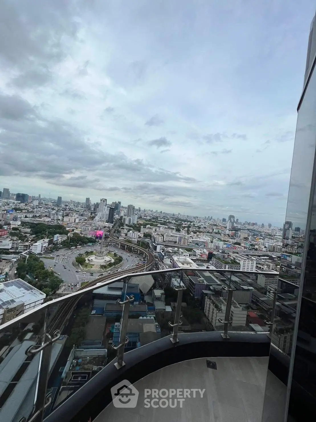 Stunning cityscape view from a high-rise balcony, showcasing urban skyline and expansive horizon.