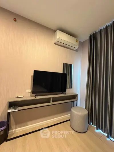 Modern living room with sleek TV setup and stylish air conditioning unit