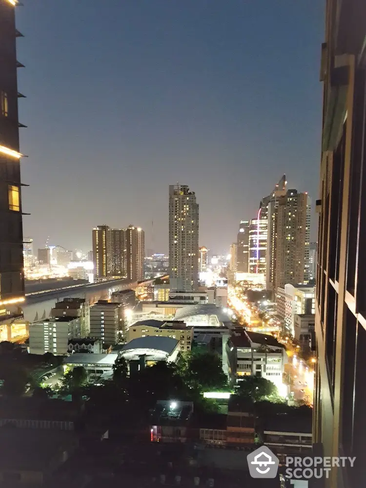 Stunning cityscape view from high-rise building at night with illuminated skyline.