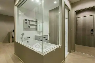 Modern apartment interior with unique glass-enclosed bathtub and sleek design.