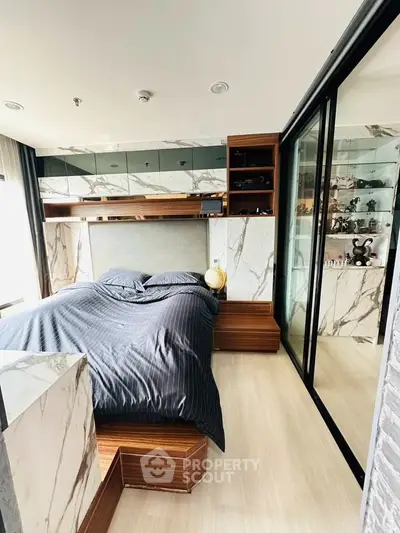 Luxurious bedroom with marble accents and sleek modern design, featuring a cozy bed and ample storage space.
