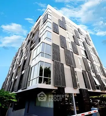 Modern architectural building with unique facade design against blue sky.