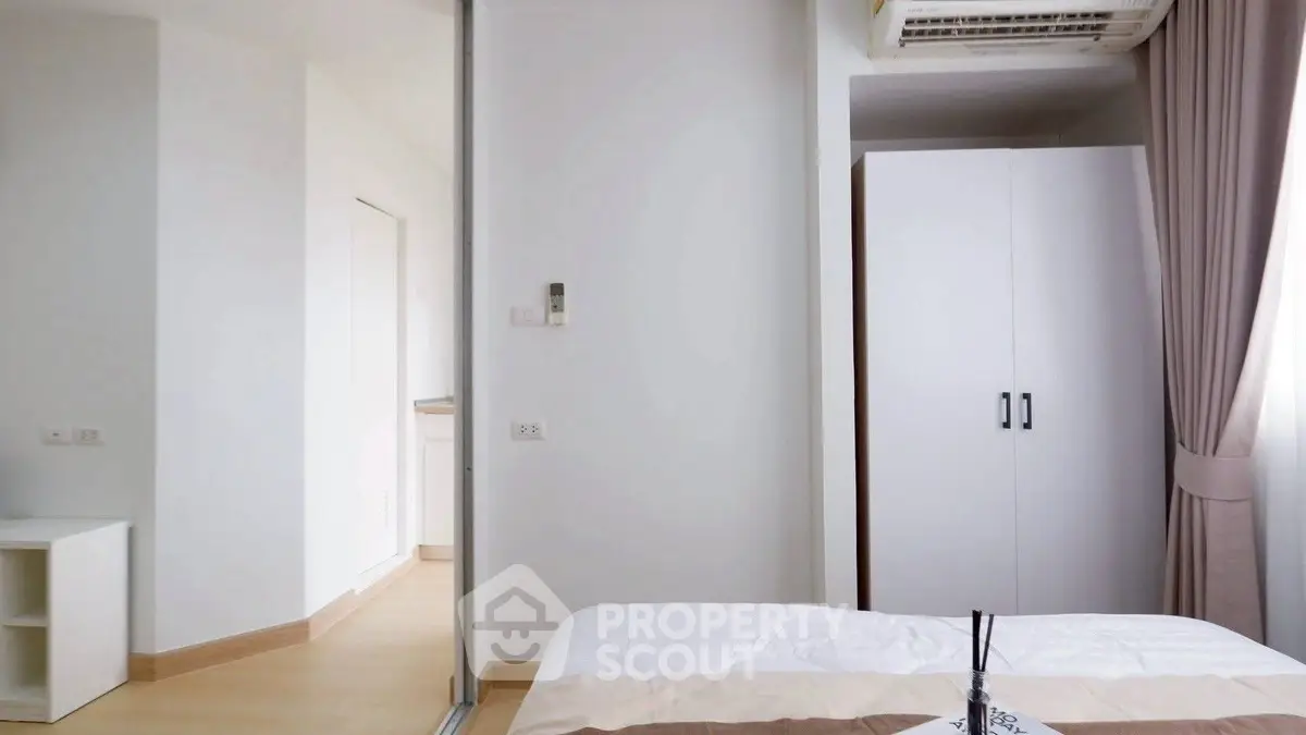 Modern bedroom with white wardrobe and air conditioning in bright apartment