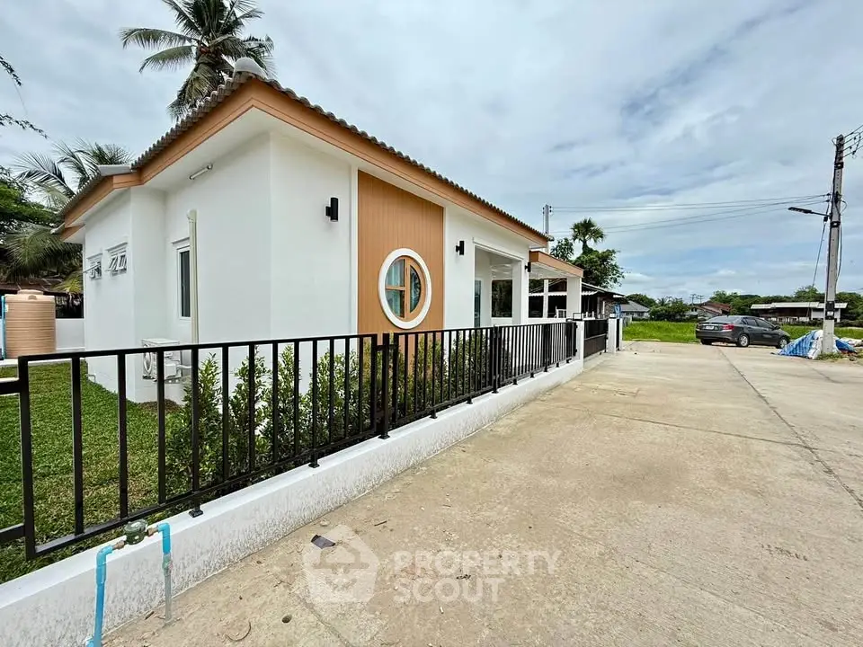 Charming modern house with unique circular window and spacious driveway in a serene neighborhood.