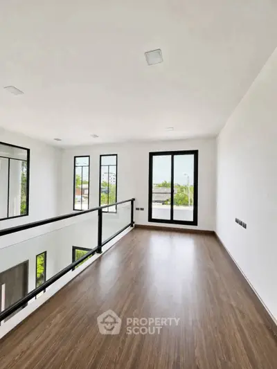 Spacious modern interior with large windows and wooden flooring, perfect for natural light and open living.