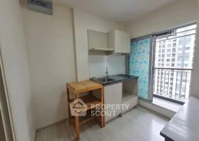 Compact kitchen with balcony view in modern apartment