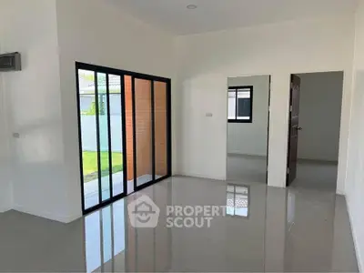 Spacious modern living room with sliding glass doors and garden view.