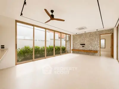 Spacious modern living room with large windows and stone accent wall