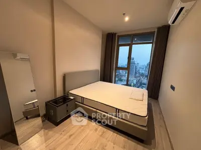 Modern bedroom with city view, featuring a sleek bed and floor-to-ceiling window.