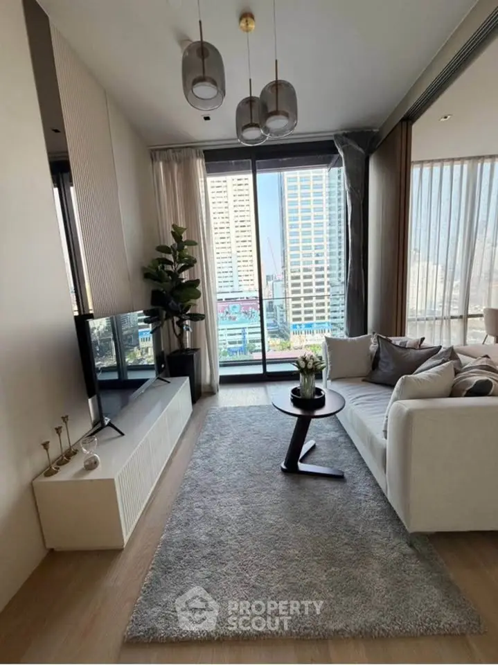 Modern living room with stylish decor and city view, featuring a cozy sofa and elegant lighting.