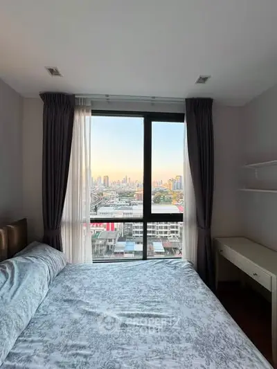 Cozy bedroom with stunning city view through large window, featuring elegant curtains and a comfortable bed.