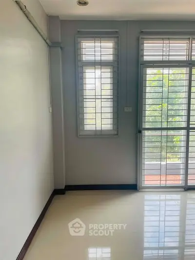 Bright room with large windows and garden view, perfect for a serene living space.