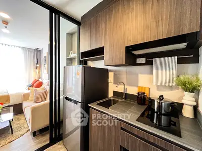 Modern compact kitchen with sleek cabinetry and cozy living area in stylish apartment