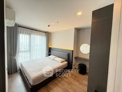 Modern bedroom with large window and stylish decor in high-rise apartment.