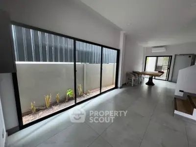 Spacious modern living area with large windows and sleek flooring, perfect for natural light and contemporary living.