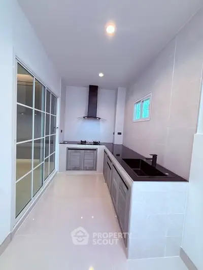 Modern kitchen with sleek design and gas stove in a bright, compact space.