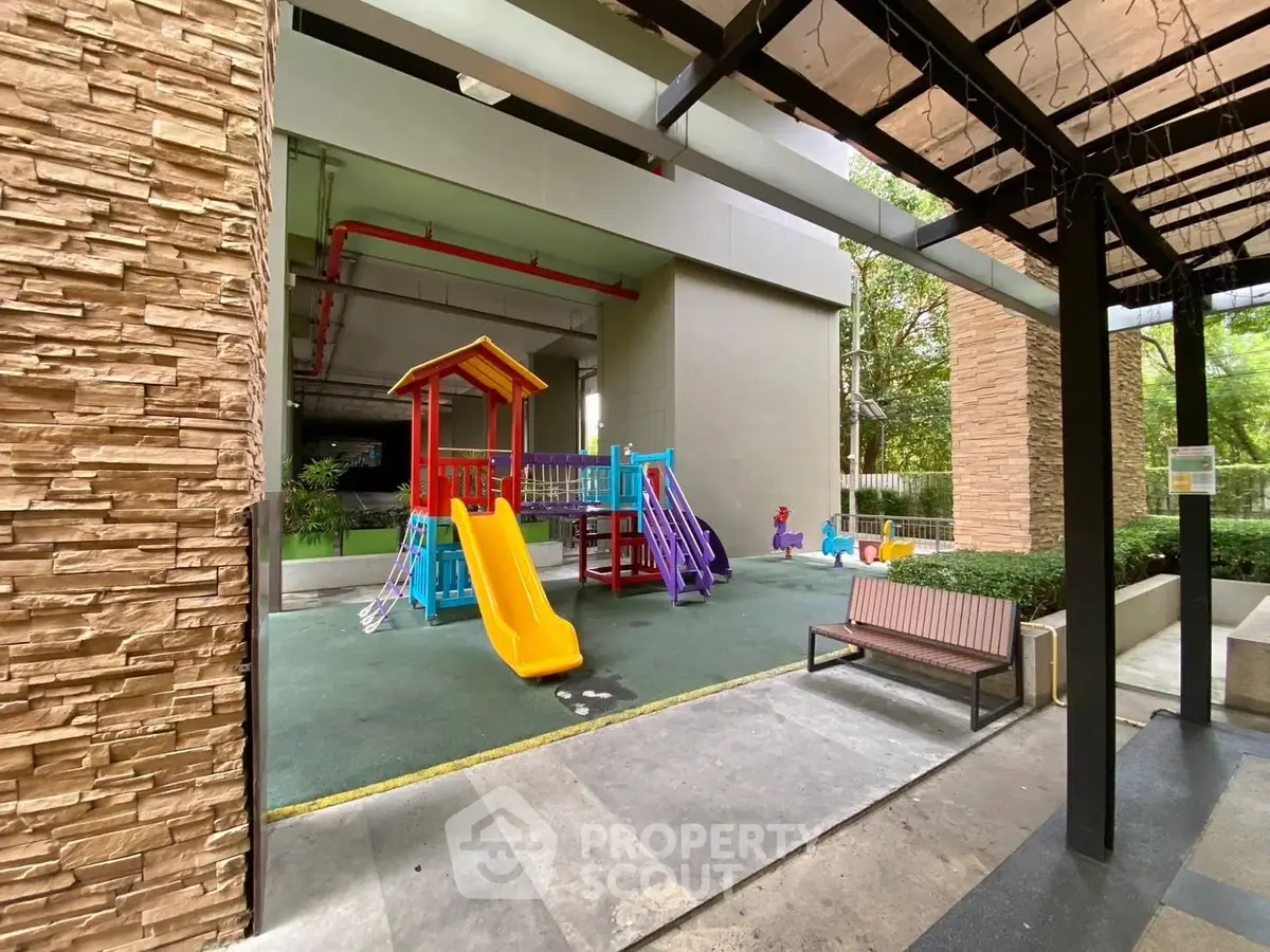 Modern residential playground with colorful slides and seating area, perfect for family living.