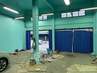Spacious industrial garage with teal walls and open entrance
