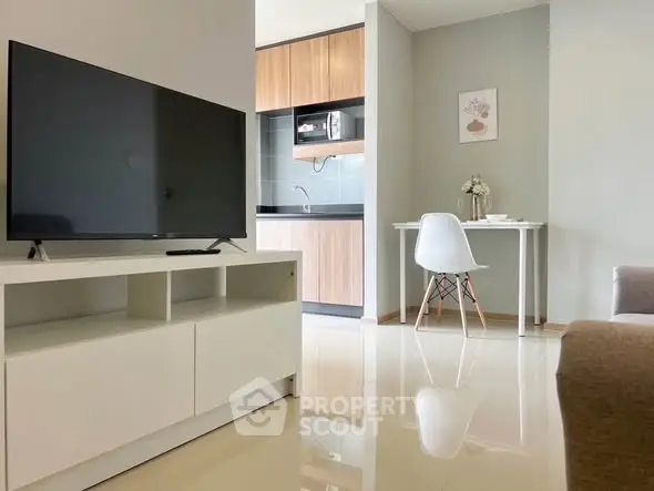 Modern living room with sleek TV stand and compact kitchen area