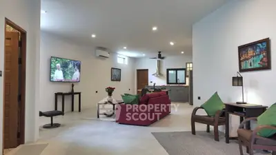 Spacious modern living room with red sofa, wall-mounted TV, and open kitchen layout.