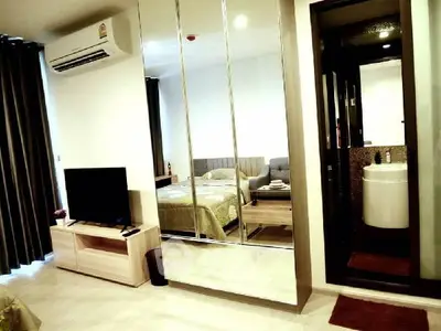 Modern bedroom with mirrored wardrobe and ensuite bathroom in stylish apartment.