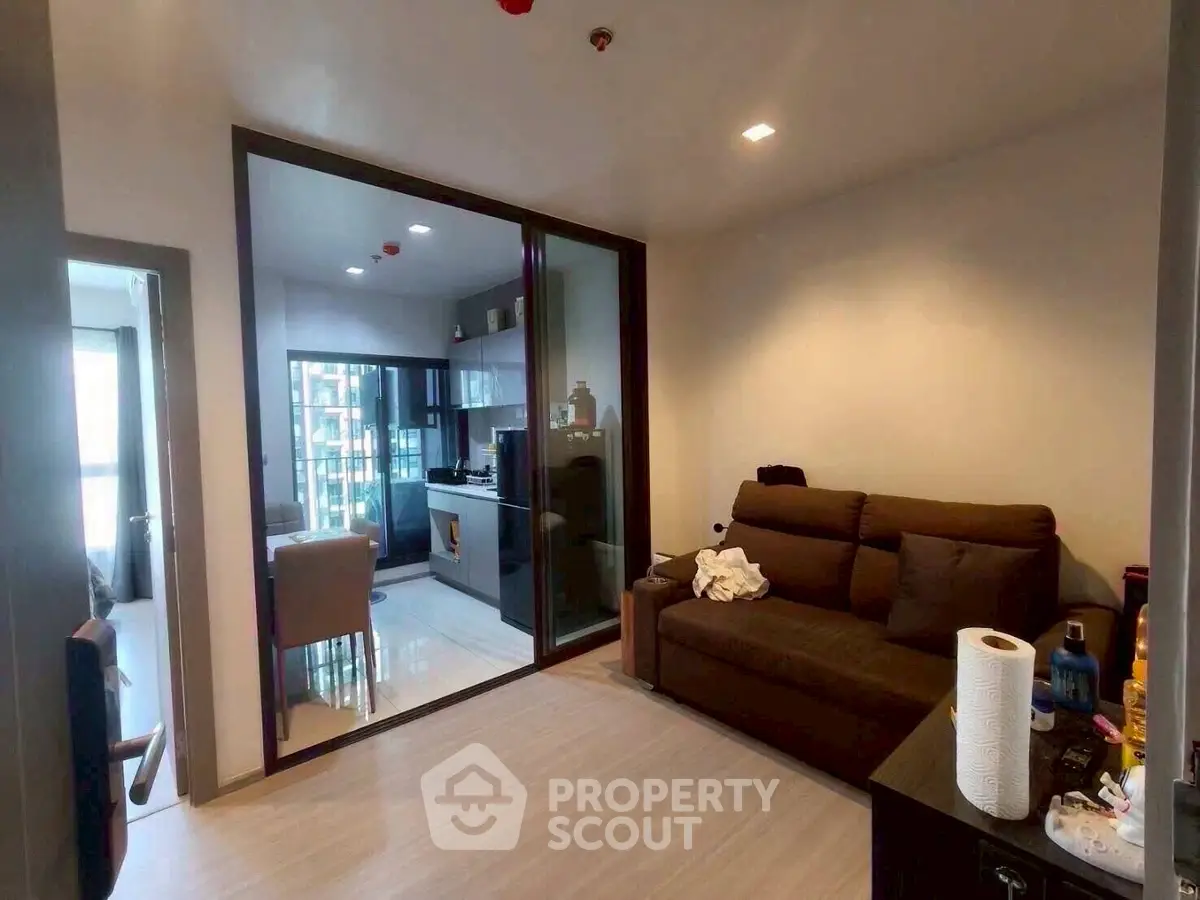 Modern living room with glass partition and cozy seating area in a stylish apartment.